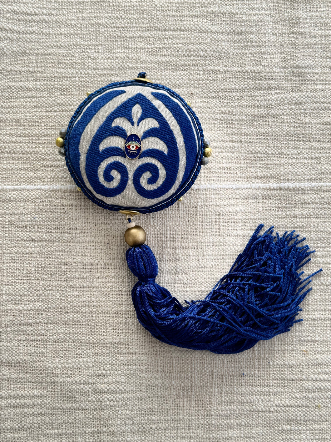 Sand colour with royal blue details round shaped charm..